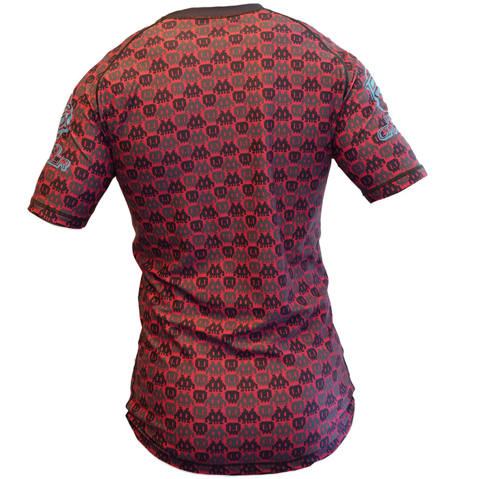 The Retro Grappler 8-Bit Pink Rash Guard is shown from the back, featuring a short-sleeved design with pink and black 8-bit patterns and black collar trim.