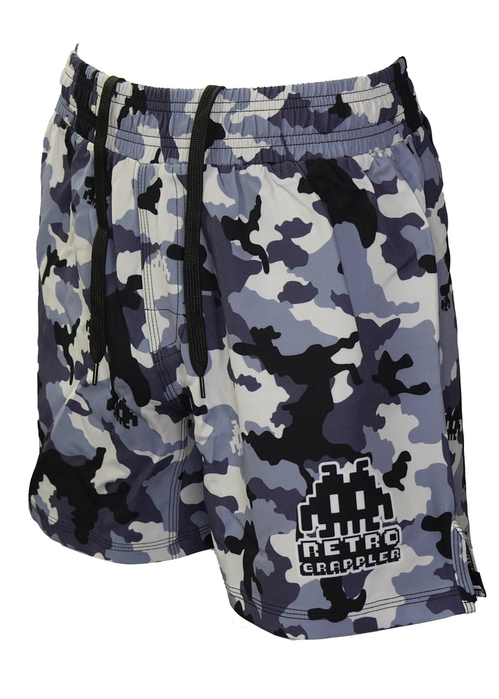 The Retro Grappler Dark Woodland Camo Kit includes blue, black, and white camo shorts with a black drawstring and pixelated logo. Pair with the matching rash guard for the ultimate training bundle.