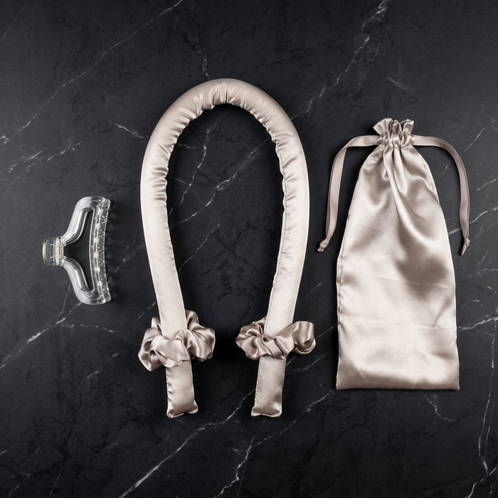 The Olla Bella Heatless Curling Headband + Satin Bag kit which includes our Satin Heatless Curling Headband, two satin scrunchies, a claw clip, and a satin drawstring bag all displayed on a dark marble background.