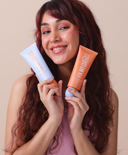 Woman holding two tubes of Curl Quenching Hair Butter and Flax Seed Gelly
