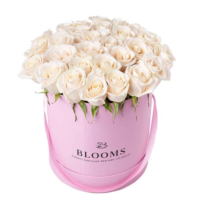 Refined White Rose Bouquet in Round Pink Hat Box – gift basket with this floral arrangement features a selection of white