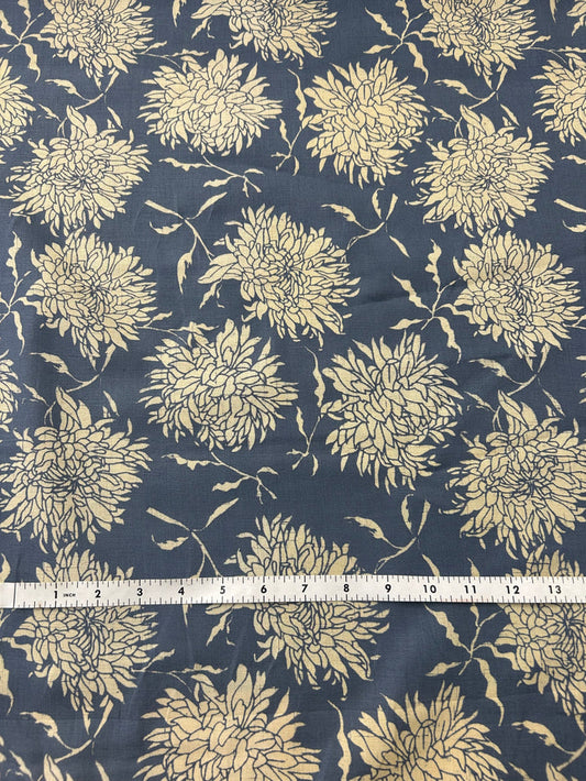 floral print fabric with off white peonies on a dark blue background, with a measuring tape on top.