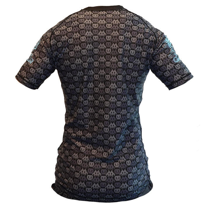 The Retro Grappler 8-Bit Grey Rash Guard is a fitted short-sleeve top featuring a black and gray ghost pattern, shown from the back on a white background, with light blue text and Retro Grappler logos on the sleeves.