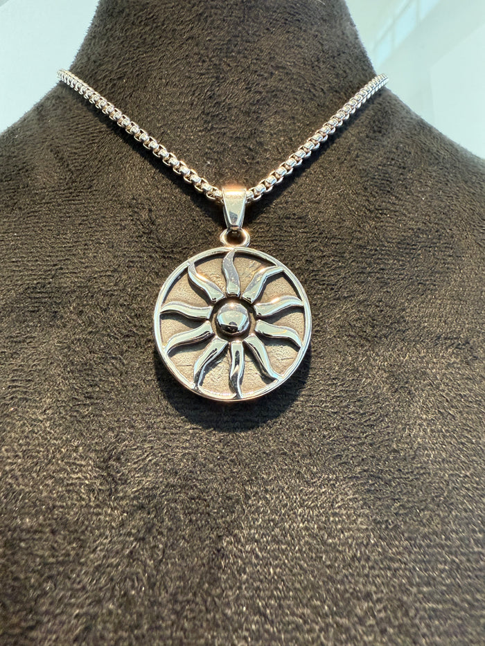 Silver titanium necklace with a sun-shaped pendant on a box link chain