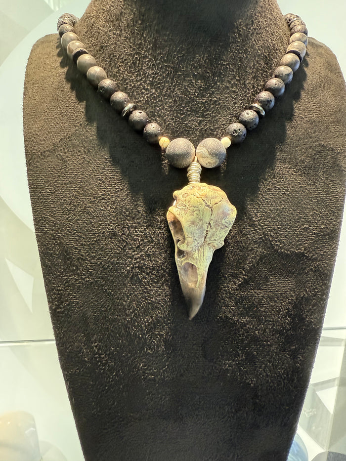 Necklace with stone pendant on a brown textured stand