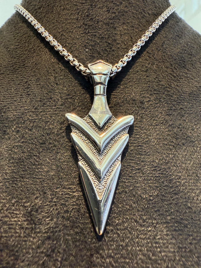 Silver Spearhead pendant on a box chain against a dark textured background