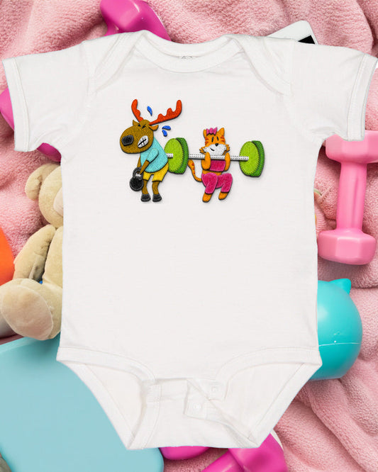 The Retro Grappler ABCs of CrossFit Baby Onesie features a cartoon moose and cat lifting weights, set on pink fabric with colorful toys and a teddy bear nearby. Includes snap closures for easy changing.