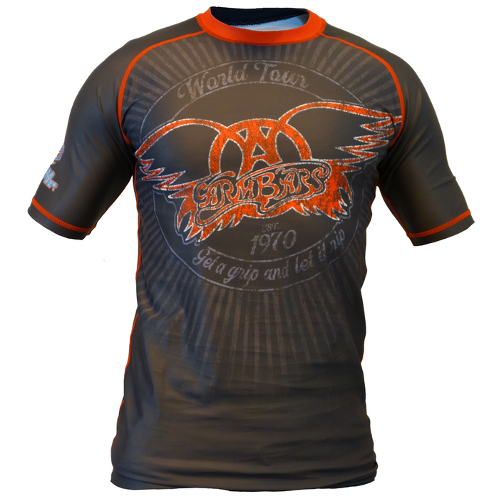 The Armbar Concert Tee Rash Guard by Retro Grappler is a fitted, short-sleeve black BJJ top with orange trim, featuring a large Aerosmith logo, World Tour text, wings, and a star—ideal for jiu jitsu or grappling sessions.