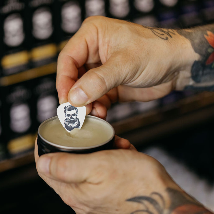 Person applying a beard balm with a branded applicator in a store setting