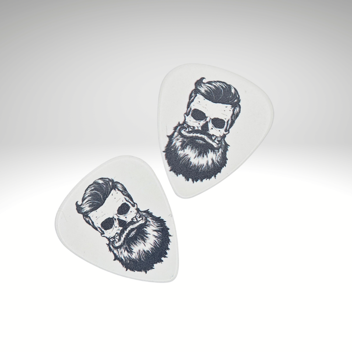 Two white guitar picks with black illustrations of bearded skulls on a light gray background