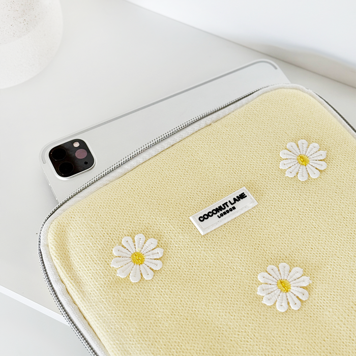 White smartphone, laptop, and floral Coconut Lane Buttercup Bloom iPad sleeve on a white surface.