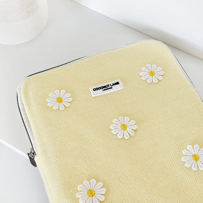 Yellow iPad sleeve with white daisy pattern and Coconut Lane label, displayed on a white surface.