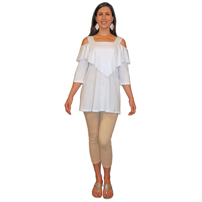 Woman wearing a white, 3/4 sleeve, flowy top with shoulder cutouts and hem that ends at the top of the thigh, and beige capri pants on a white background.