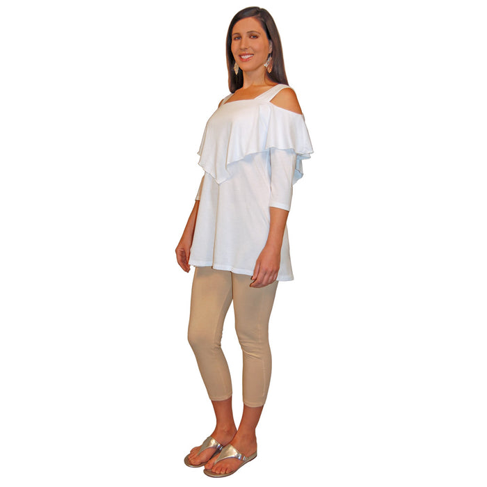 Quarter turn view of a woman wearing a white, 3/4 sleeve, flowy top with shoulder cutouts and beige pants on a white background.