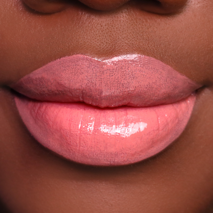 City Girl coral nude lip gloss on lips, medium-deep skin tone