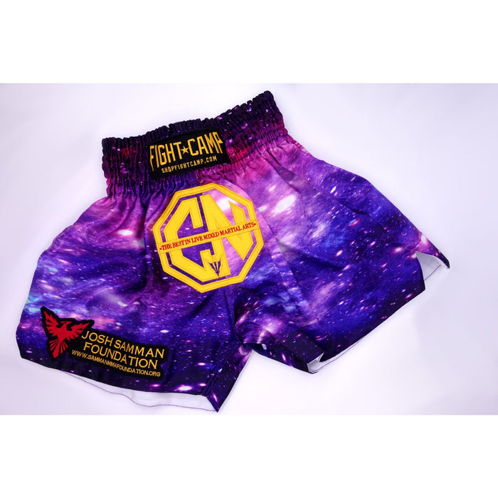 Combat Night Galaxy Muay Thai shorts feature a purple and pink galaxy pattern, yellow Combat Night logos, Josh Samman Foundation logo in red, and website URLs on the waistband and leg. Perfect for kickboxing or Muay Thai training.