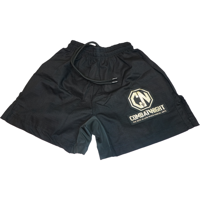 The Retro Grappler Combat Night Gi Shorts are black athletic shorts made from lightweight rip-stop fabric, featuring a drawstring waist and a white-and-gold Combat Night hexagon logo with CN initials on one leg.