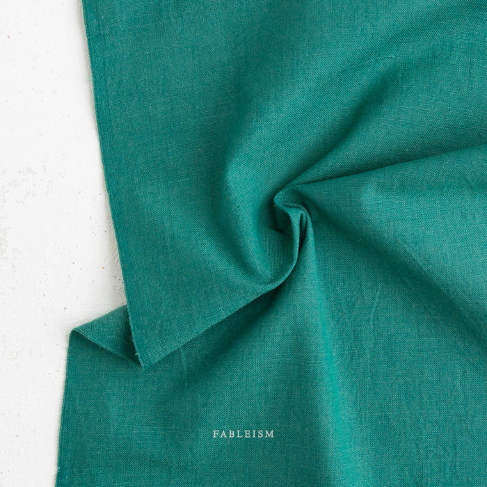 Teal green fabric with 'Fableism' branding on a white background
