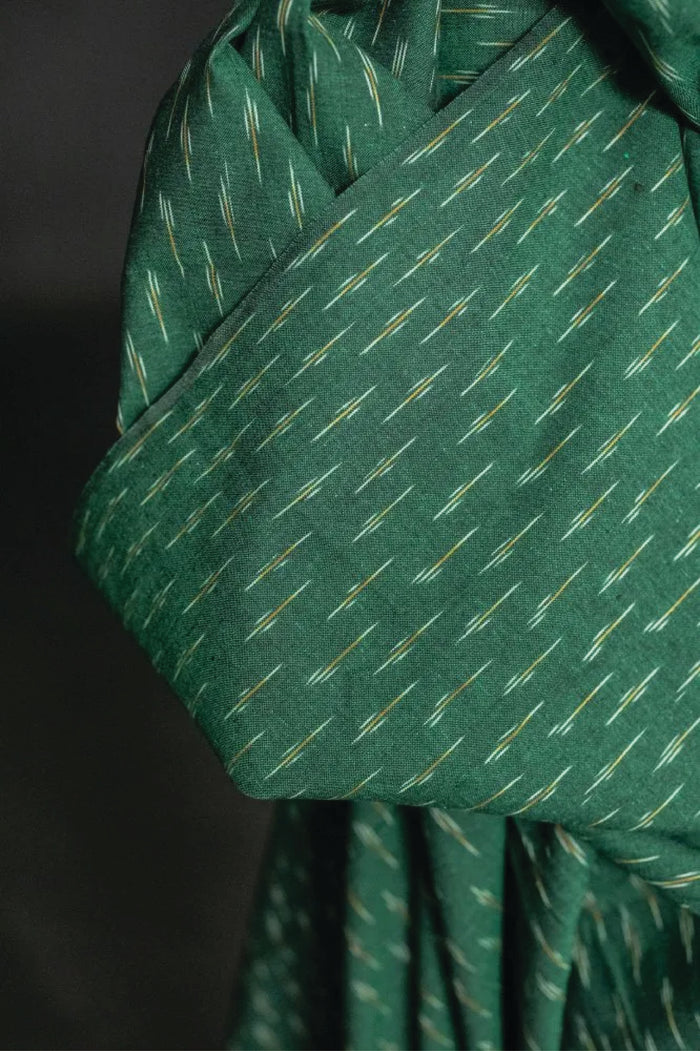 A stunning chequered Ikat weave with ochre and white dashes on a background of dark emerald green.