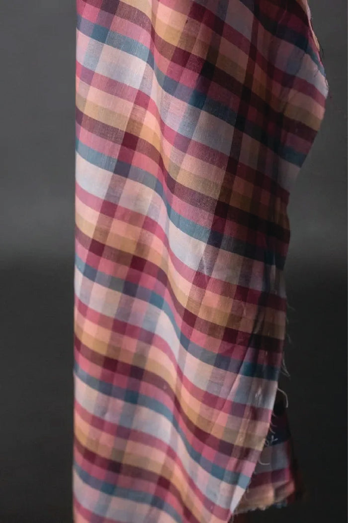 Multicolored plaid fabric against a dark background