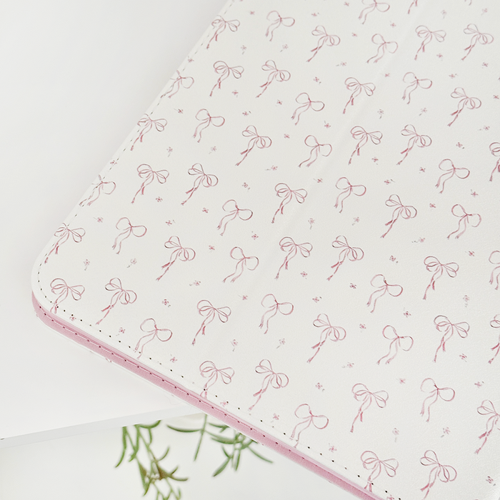 Coconut Lane iPad case with pink bows and green leaves on a white background.