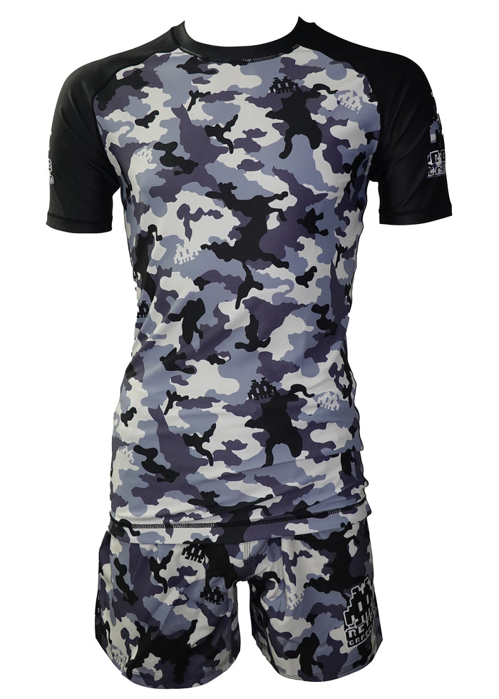 The Retro Grappler Dark Woodland Camo Kit bundles a short-sleeved rash guard and shorts in gray, black, and white camo, both with black accents on the sleeves and sides.