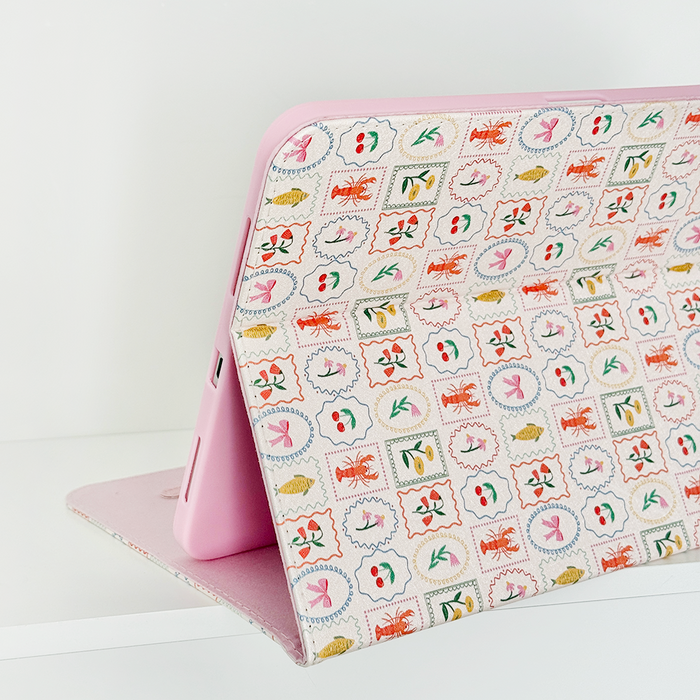 Pastel iPad case with colorful stamps of ants, leaves, and flowers by Coconut Lane.