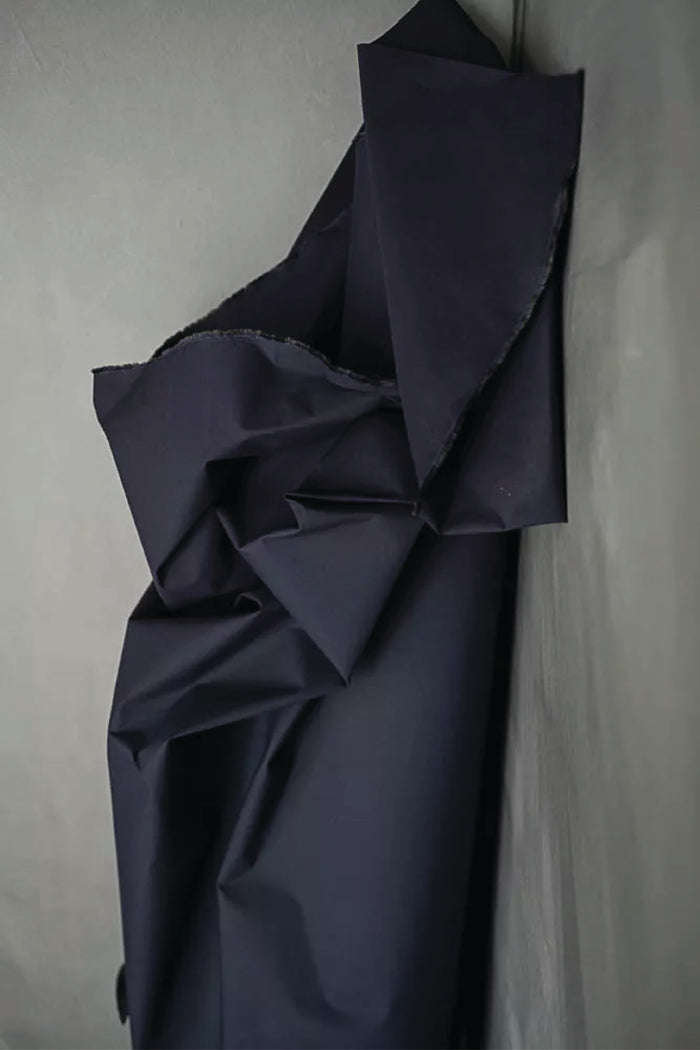 Navy blue fabric draped over a light grey green surface