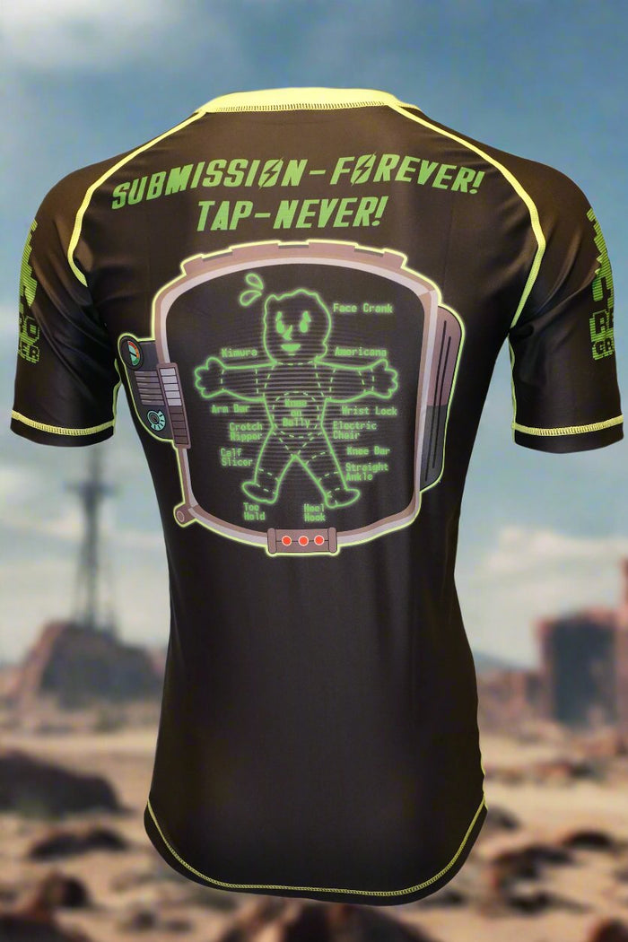 The Retro Grappler Fallout Wasteland Grappler Rash Guard is black with neon green trim, features a cartoon Pip-Boy V.A.T.S.–inspired figure labeled by body parts, “SUBMISSION–FOREVER! TAP–NEVER!” on the shoulders, and a blurred wasteland background.