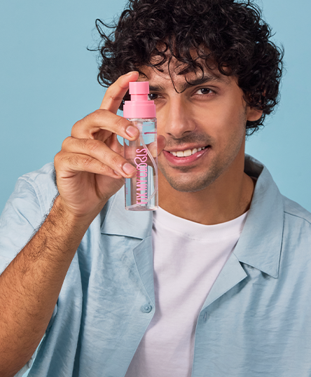 Man holding Floral Bouquet Hair Mist of Fix My Curls with a blue background