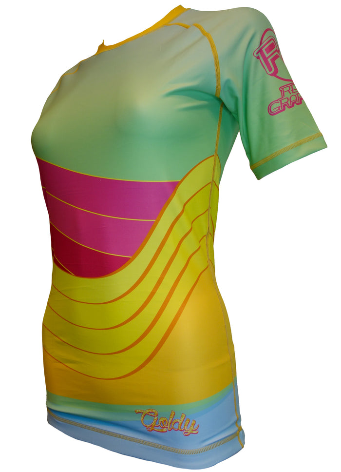 The Golden Waves BJJ Rash Guard by Retro Grappler is a short-sleeved, fitted athletic top with an abstract design of yellow, green, pink, and blue curved stripes, plus logos and text on the sleeve and lower front.