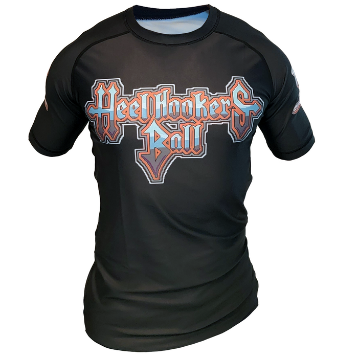 The Retro Grappler Heel Hookers Ball Heel Hook Rash Guard is a black, fitted short-sleeve shirt with visible stitching and “Heelhookers Ball” in red and white across the chest, inspired by jiu jitsu rash guards.