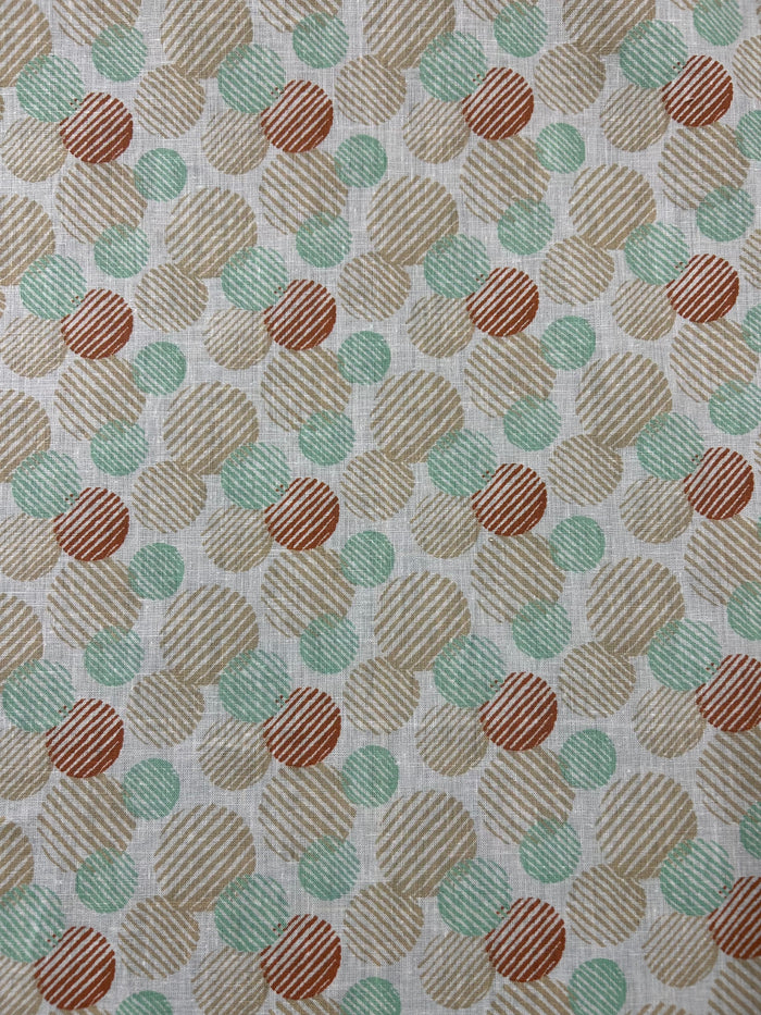 Linen fabric with a a retro abstract polka dot print fabric in mint, beige, and rust on an ivory background. The circles vary in size and are filled with fine diagonal stripe textures, creating a layered geometric look with a hand-printed feel.