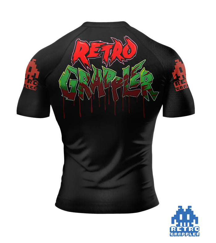 The Retro Grappler Jason V Horror Jiu Jitsu Rash Guard is black with pixelated red sleeve designs, graffiti-style Retro Grappler text on the back, and a blue pixelated Retro Grappler logo at the bottom right.