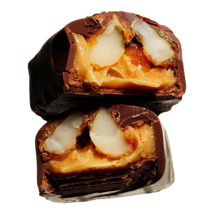 Close-up of a chocolate-covered candy with a visible filling on a white background.