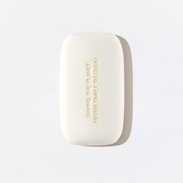 Reverse image of a white bodywash bar from Fussy, with the words 'Saving The Planet Never Smelt So Good' engraved in the bar.