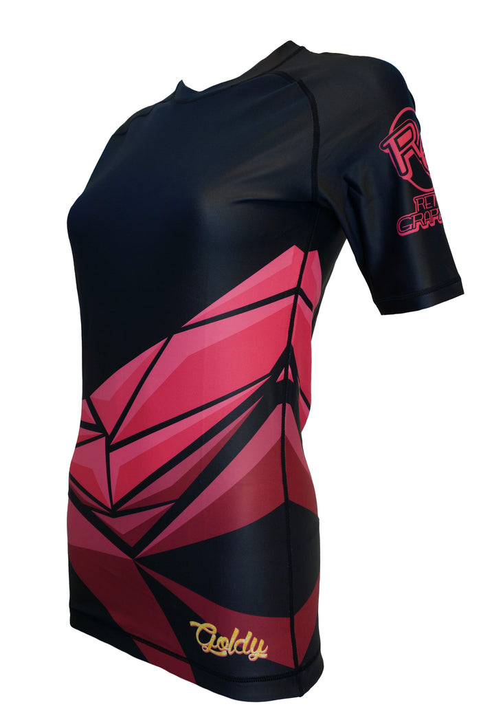 The Retro Grappler Night Breaks BJJ Rash Guard is a fitted short-sleeve athletic shirt with abstract red and pink geometric patterns on black, featuring logos on the left sleeve and lower front.