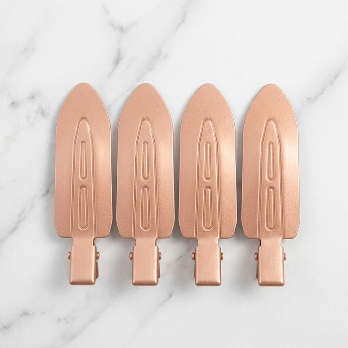 Four Olla Bella No-Crease Cuties - Creaseless Hair Clips arranged in a row on a white marble background.