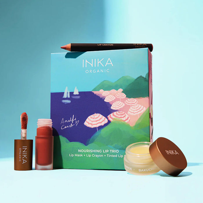 INika Organic lip care products including a lip mask, lip crayon, and tinted lip balm on a blue background.
