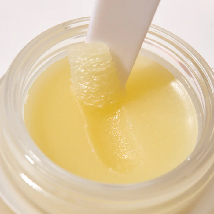 Jar of yellow substance with a white applicator stick.