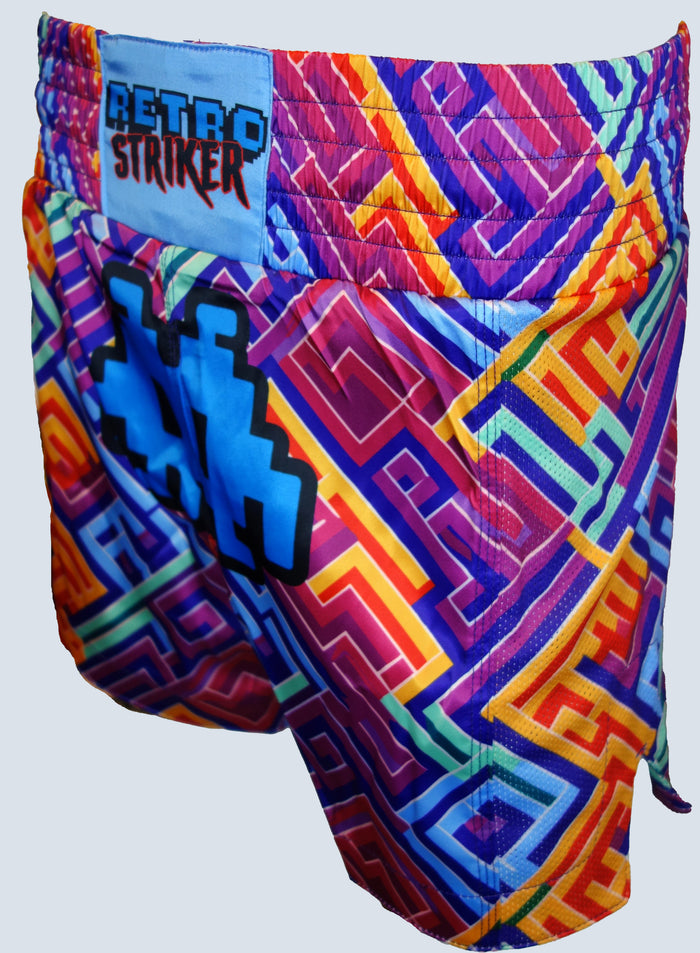 Retro Grapplers Puzzle Muay Thai Shorts are lightweight and colorful, featuring a vibrant geometric maze in red, yellow, blue, and purple with a RETRO STRIKER patch on the waistband and a blue pixel number on the left side.