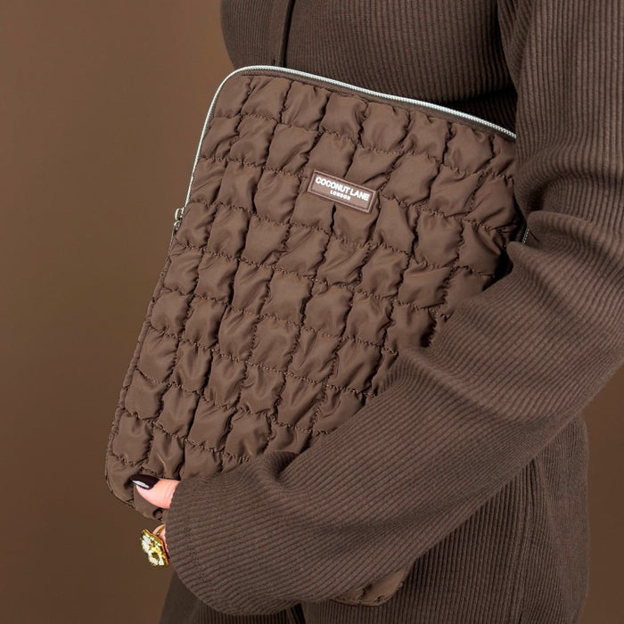 Coconut Lane Quilted Chocolate iPad Sleeve held by person in brown ribbed outfit, with a matching brown background.
