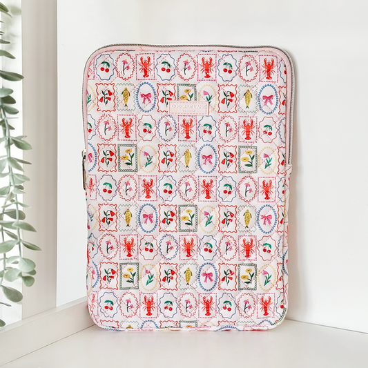 White quilted iPad sleeve with colorful seafood and floral stamp pattern by Coconut Lane.
