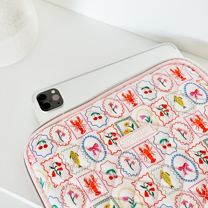 Quilted iPad sleeve with a colorful pattern of lobsters, cherries, and flowers.