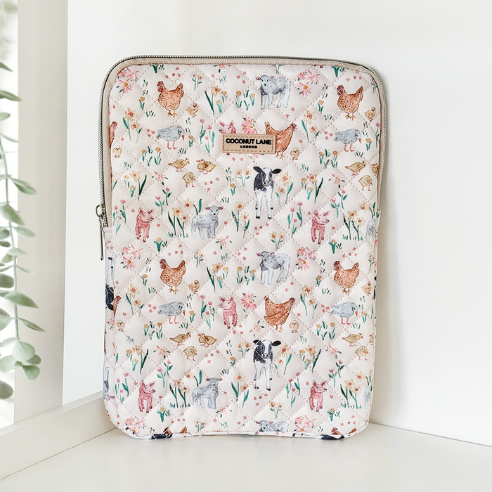 Quilted iPad sleeve from Coconut Lane featuring a playful farmyard animal print with cows, goats, and chickens.
