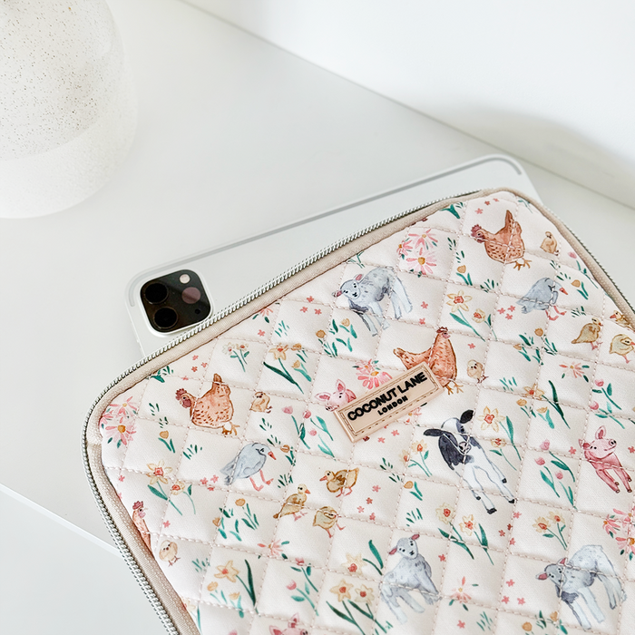 Quilted Farmyard Friends iPad sleeve from Coconut Lane partially covers a silver iPad on a white desk.