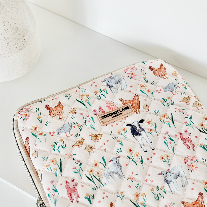 Quilted iPad sleeve with farm animal and floral print, featuring soft pastel colors and a cozy fabric finish.