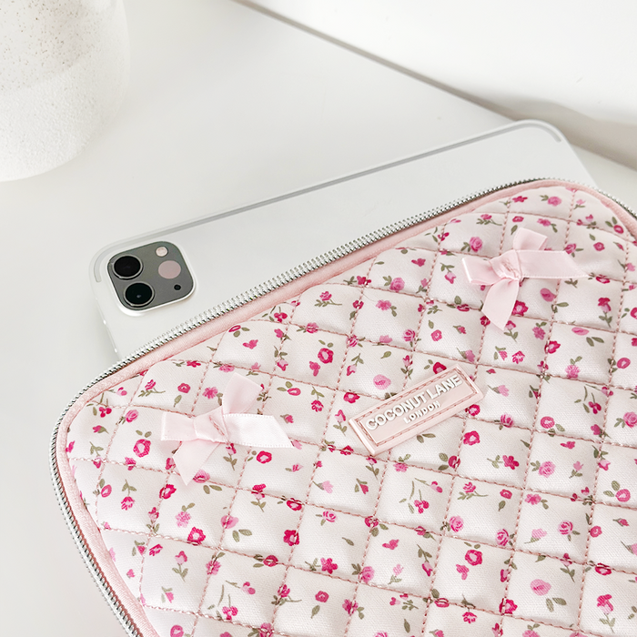 Silver iPad inside a quilted pink floral Coconut Lane sleeve, resting on a white surface.