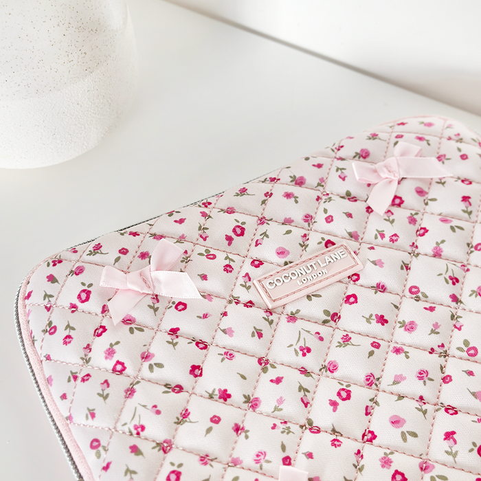 Pink quilted iPad sleeve with watercolour floral pattern, small bows, and a Coconut Lane label.