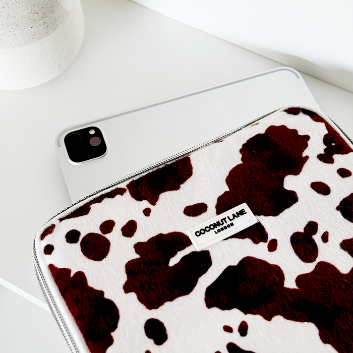 Coconut Lane Rodeo Cowgirl iPad sleeve with black and white cow print on a smooth white background.